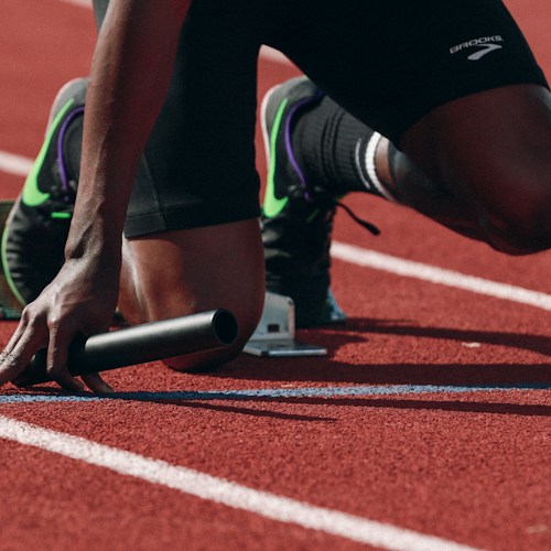An athlete on a running track, shown as an illustrative placeholder for the Games programme